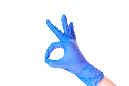 Blue latex medical gloves on a female hand, shows the character okay