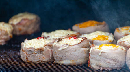 Cooking meatballs covered with bacon on the grill of barbecueの写真素材