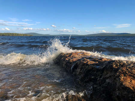storm waves hitting a rock on a lake in the North of Russia in the countryの写真素材