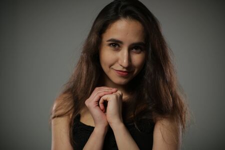 A young brunette with a smile looks at the camera.の写真素材