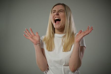 The artistic woman demonstrates bright emotions of delight cry and joyの写真素材