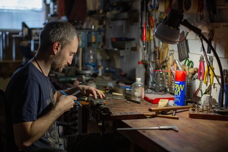 A man master sits at his Desk and measures the caliper blank for the product.の写真素材