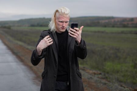 The guy looks in the phoneâ€™s selfie camera