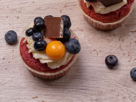 Sweet cupcakes with blueberries, cream mousse and chocolate. Delicious homemade cakes. Photo for...