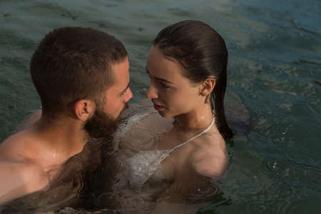Beautiful couple in love romantically hug and kiss in the sea. Vacation on the sea on the beach,...