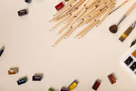 many colored pencils, watercolor paints and brushes are beautifully laid out on a light background, the view from above. The concept of creativity. High quality photoの写真素材