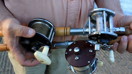 A fishing man shows his collection of classic reels.の写真素材