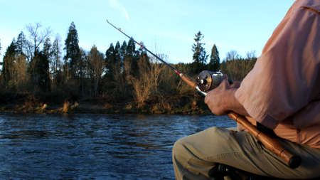 This is an image of a man holding a fishing pole.の写真素材