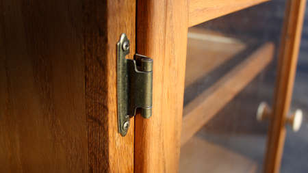 This is a metal hinge for a piece of furniture.