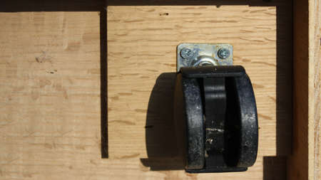 This is a plastic wheel found under wooden furniture.の写真素材