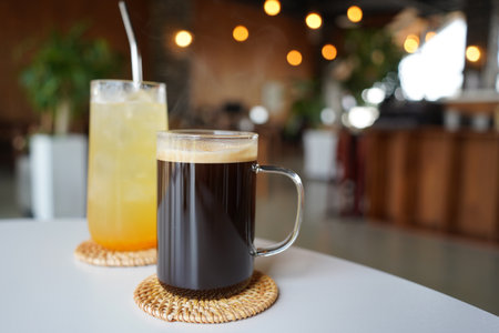 Coffee and orange juice in a glass on the table.