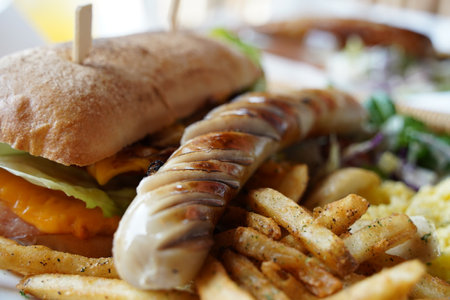 Sandwich with grilled sausages and french fries on wooden tableの写真素材