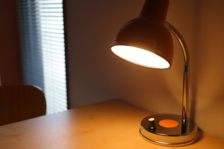 Lamp on a table in a room with window blinds.の写真素材