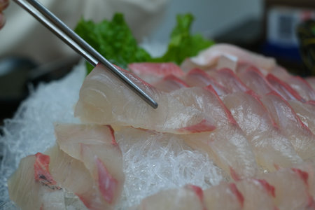 Raw fresh fish sashimi with chopsticksの写真素材