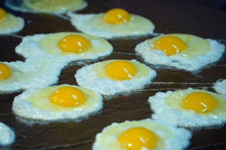 Close-up of Freshly Fried Sunny-Side-Up Eggs on a Griddleの写真素材