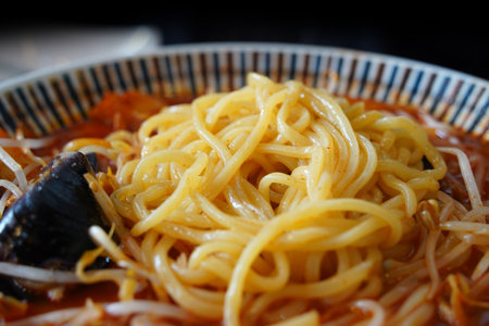 Close-up of Spicy Korean Jjambbong Noodles with Red Soupの写真素材
