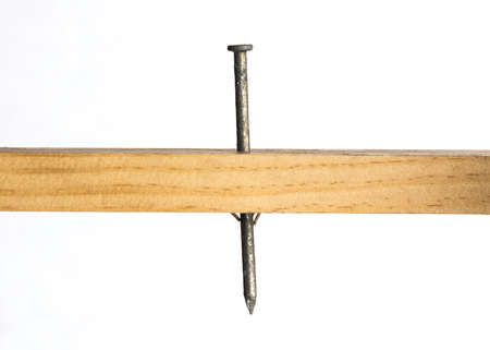 A galvanized nail protrudes through a piece of woodの写真素材