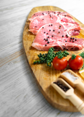 Raw pork steak - ready for cooking with herbs on wooden boardの写真素材