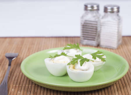 boiled eggs with mayonnaise and parsley on a plate
