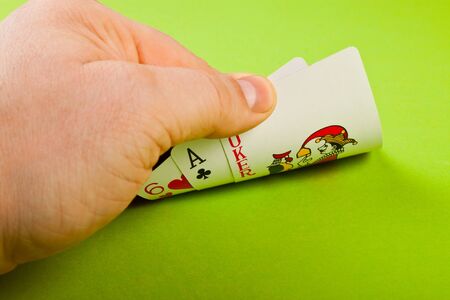 player's hand lifts the cards on green backgroundのeditorial素材