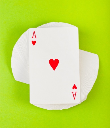 twisted a deck of cards on green backgroundの写真素材