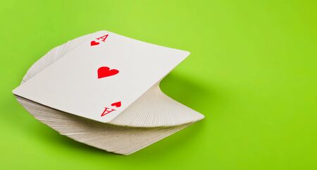 twisted a deck of cards on green backgroundの写真素材