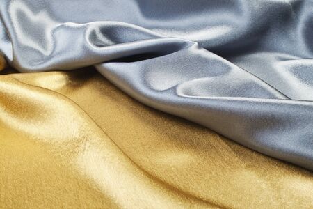Smooth elegant gold and silver silk can be used as backgroundの写真素材
