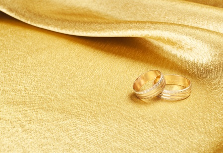 Gold wedding rings lying on silkの写真素材