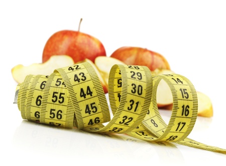 Red apple with yellow measuring tape on white background の写真素材