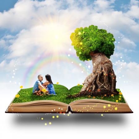 Young couple sitting on the grass near the magic tree of love.の写真素材