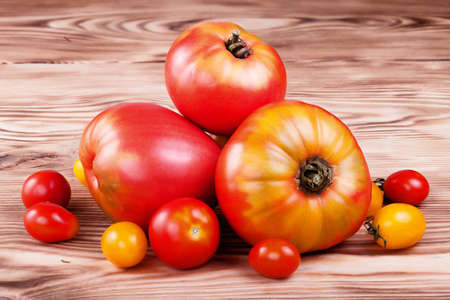 Fresh ripe tomatoes on a wooden boardの写真素材