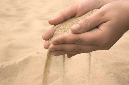 Hands strew sand,Fingers of hands and sandの写真素材