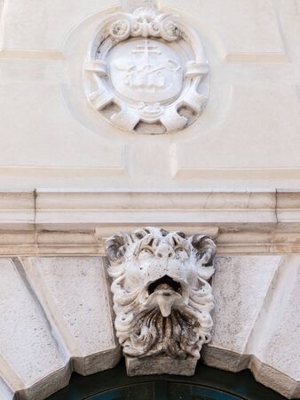 A carving of a Lions head over an archway in Venice, Italyの写真素材