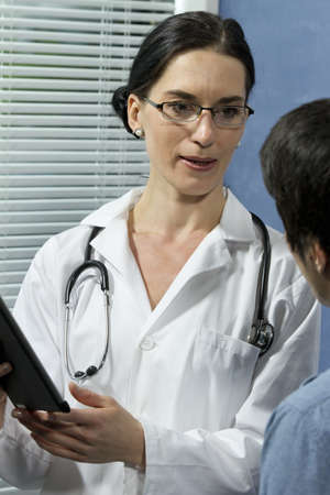 Female doctor talking with patient, verticalの写真素材