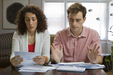 Young couple reviewing bills, horizontalの写真素材