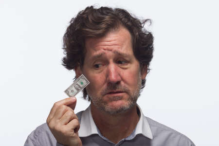 Man looks sad with dollar bill, horizontalの写真素材