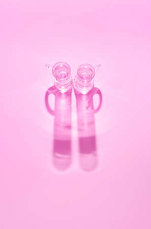 Two tequila glasses on pink background. Minimal flat lay.の写真素材