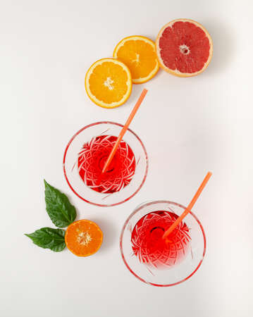 Cocktails or refreshment with straws arranged with tropical fresh slices of fruits. Minimal flat lay.の写真素材
