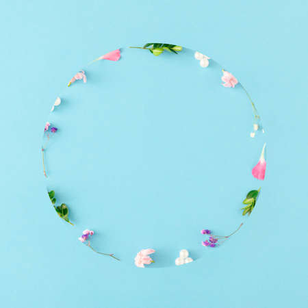 Creative spring layout made of colorful flowers, leaves and pearls on pastel blue background with copy space. Minimal nature concept. Flat lay.の写真素材