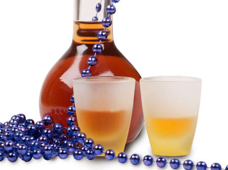 bottle of brandy, glasses and purple beadsの写真素材