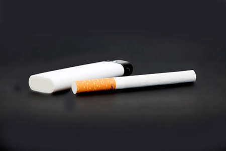 white lighter and one cigarette on gray backgroundの写真素材