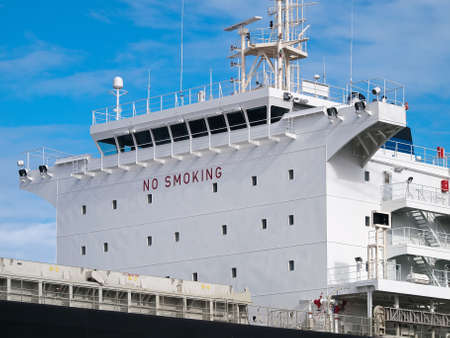 Cargo ship anchored in port, side view of ship's superstructureのeditorial素材