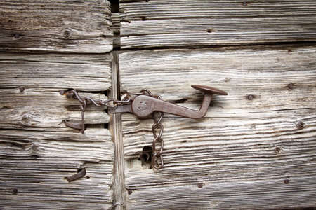 closed old wooden door with rusty chainの写真素材