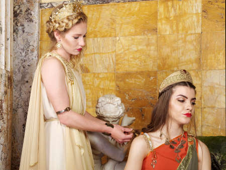 women in traditional roman clothing posing in templeの写真素材