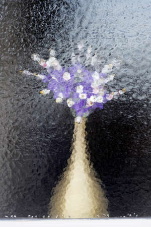 bouquet of flowers behind blurred windowの写真素材