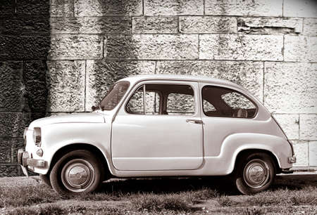 PULA, CROATIA - DECEMBER 9, 2016: Zastava 750 classic, white color oldtimer supermini car parked on grass against old wall in Pula, Croatia.のeditorial素材