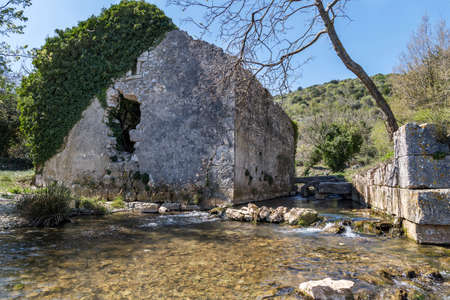 ruined ivy covered house and pure spring water in early spring in Blaz Bay, Istria, Croatiaの写真素材