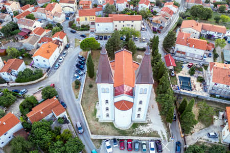 An aerial shot church of Sv. Agnes with two bell towers 33 m high, in Medulin at dusk, Istria,...