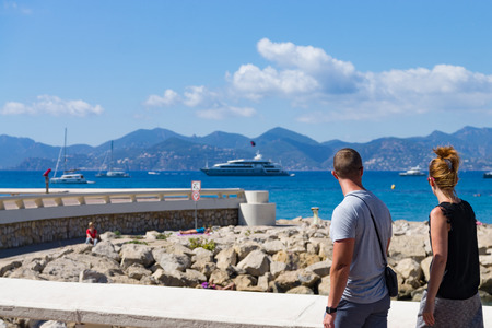Couple walking along the stone coast of Cannes, Cote d'Azurの写真素材