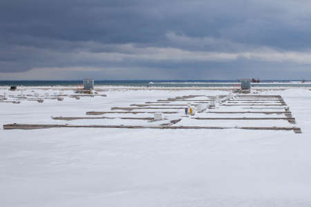 Boat slips are frozen in while the Lighthouse Point Marina in Collingwood, Ontario, experiences winter storms and the freezing temperatures of Georgian Bay.の写真素材